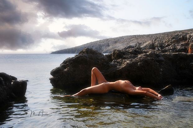lying on the rocks artistic nude photo by photographer manolis tsantakis