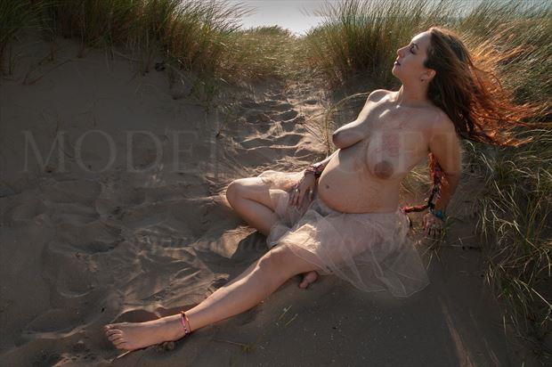 omani pregnant in the sand dunes wind blowing her hair artistic nude photo by photographer ian cartwright
